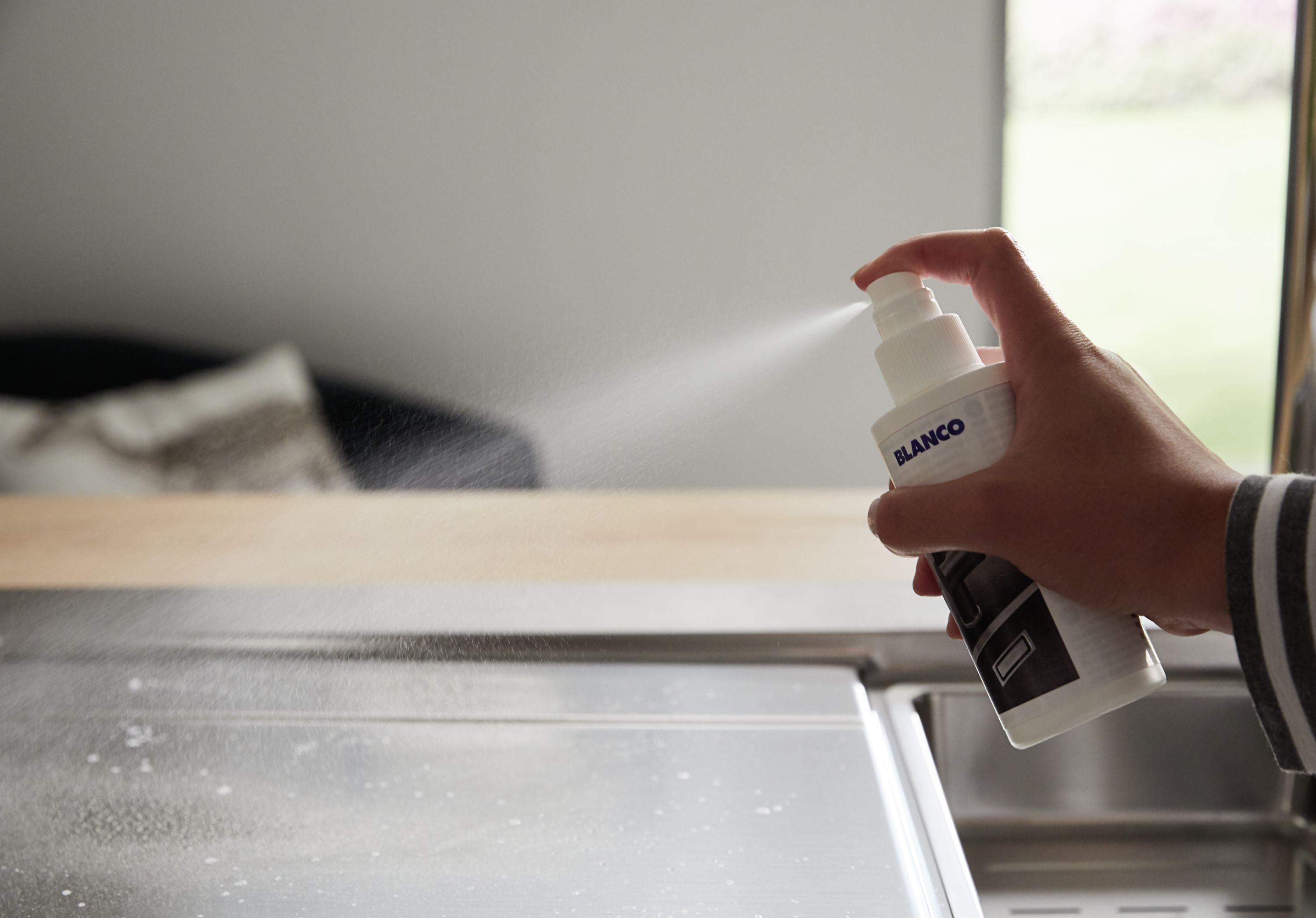BLANCO Edelstahlspüle wird mit BLANCO DailyClean+, dem professionellen Kalkentferner eingesprüht.